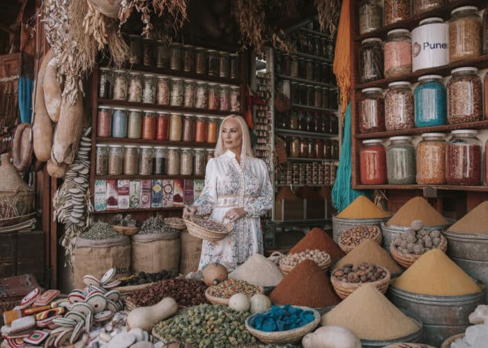 Woman in Moroccan spice market surrounded by colorful spices